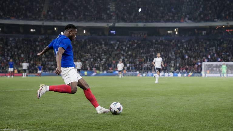 Un ailier de l'équipe de France déborde un défenseur belge dans un stade plein pendant France-Belgique