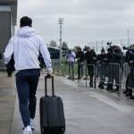 Un joueur du Real Madrid quitte le centre d’entraînement, valise à la main, entouré de médias.