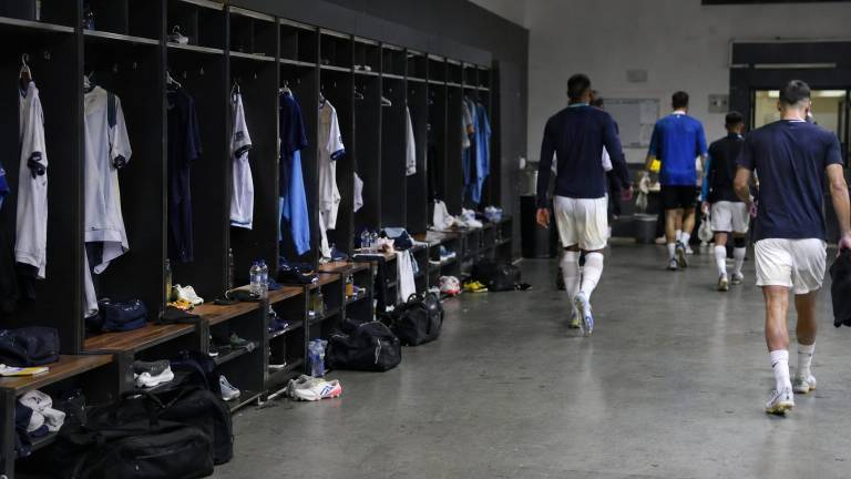 Vestiaire du Real Madrid déserté par les joueurs après un match tendu, ambiance lourde.